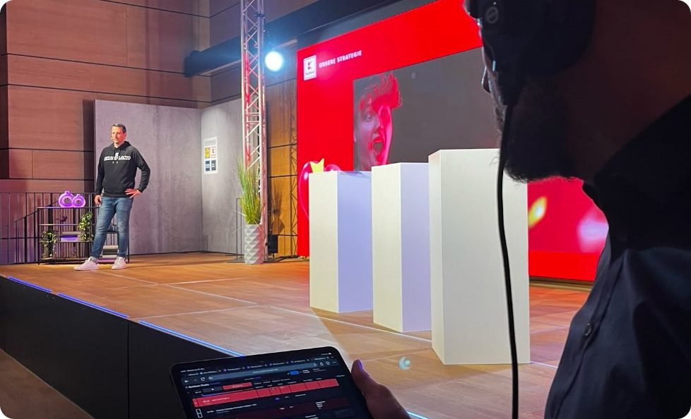 A man on stage with a live rundown control interface on a tablet in the foreground